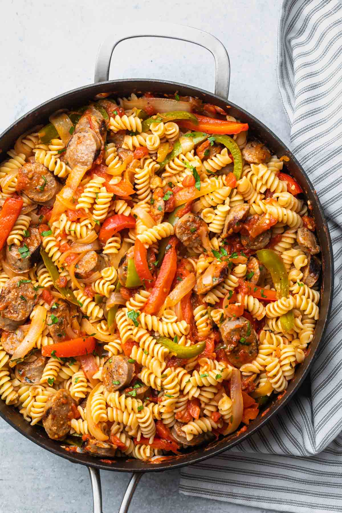rotini pasta with sausage peppers and onions in a large skillet